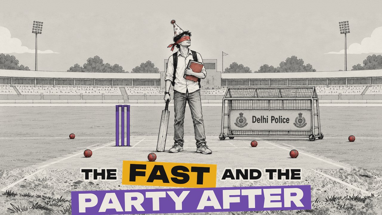 A blindfolded student in a party hat stands on a cricket pitch holding a rule book and a bat, beside purple stumps and a police barricade.